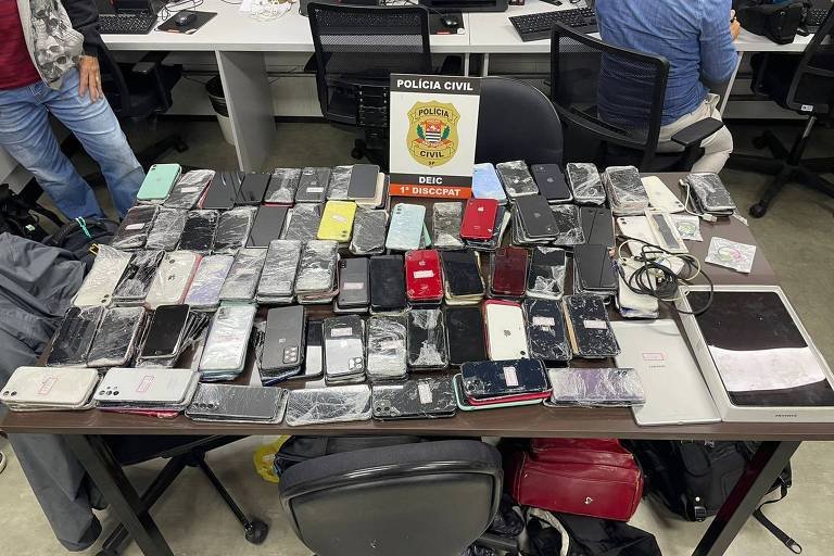 Quanto Tempo Um Celular Pode Ficar Apreendido Pela Polícia 25 celular em uma mesa de evidencias policiais