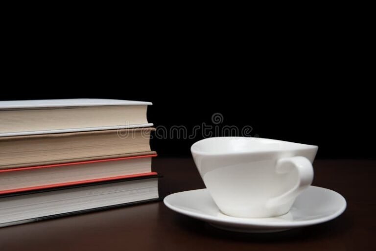 livros empilhados com uma xicara de cafe