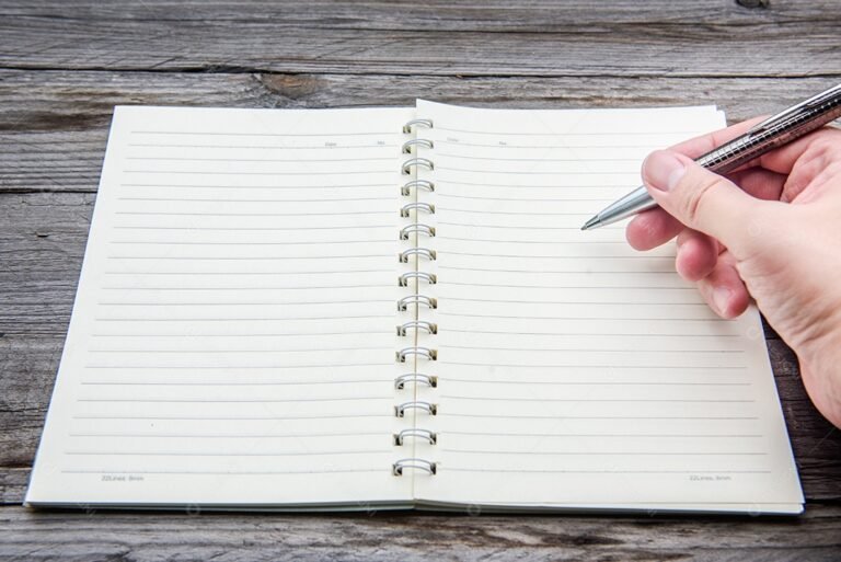 maos escrevendo em um caderno aberto