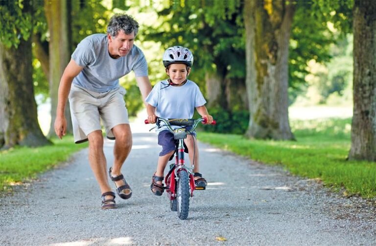 pai ensinando filho a andar de bicicleta