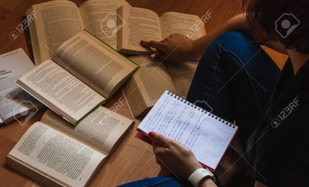 Como Fazer um Curso Eficiente sobre Impostos e Tributos 1 pessoa estudando com livros e anotacoes