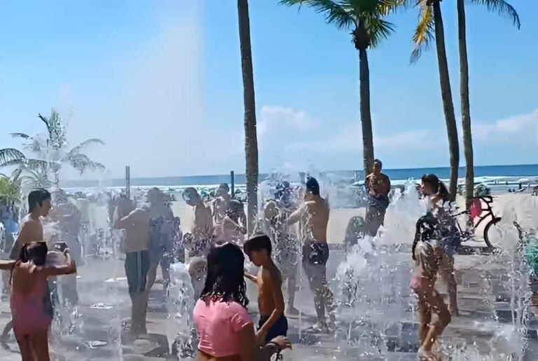 praia grande com pessoas se divertindo