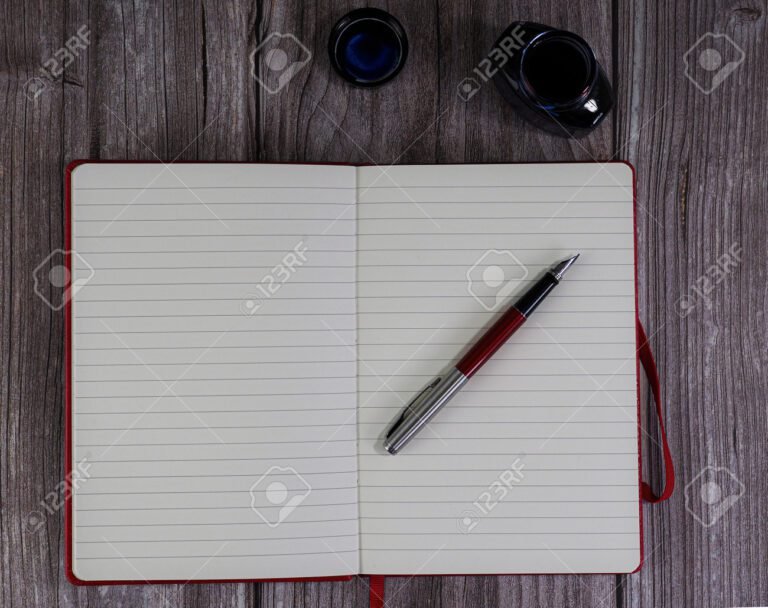 uma caneta escrevendo em um caderno aberto